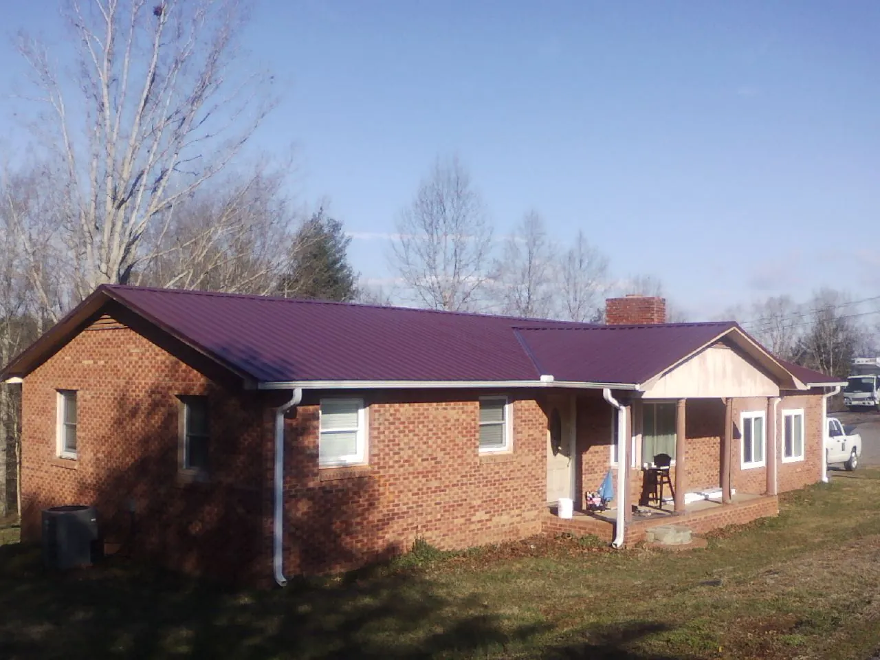 Burgundy metal roof on a brick ranch home with a new addition in Blacksburg