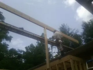 Carpenter setting a ridge beam over a new addition frame — Ice Dam Removal by Roofing Brothers in Blacksburg
