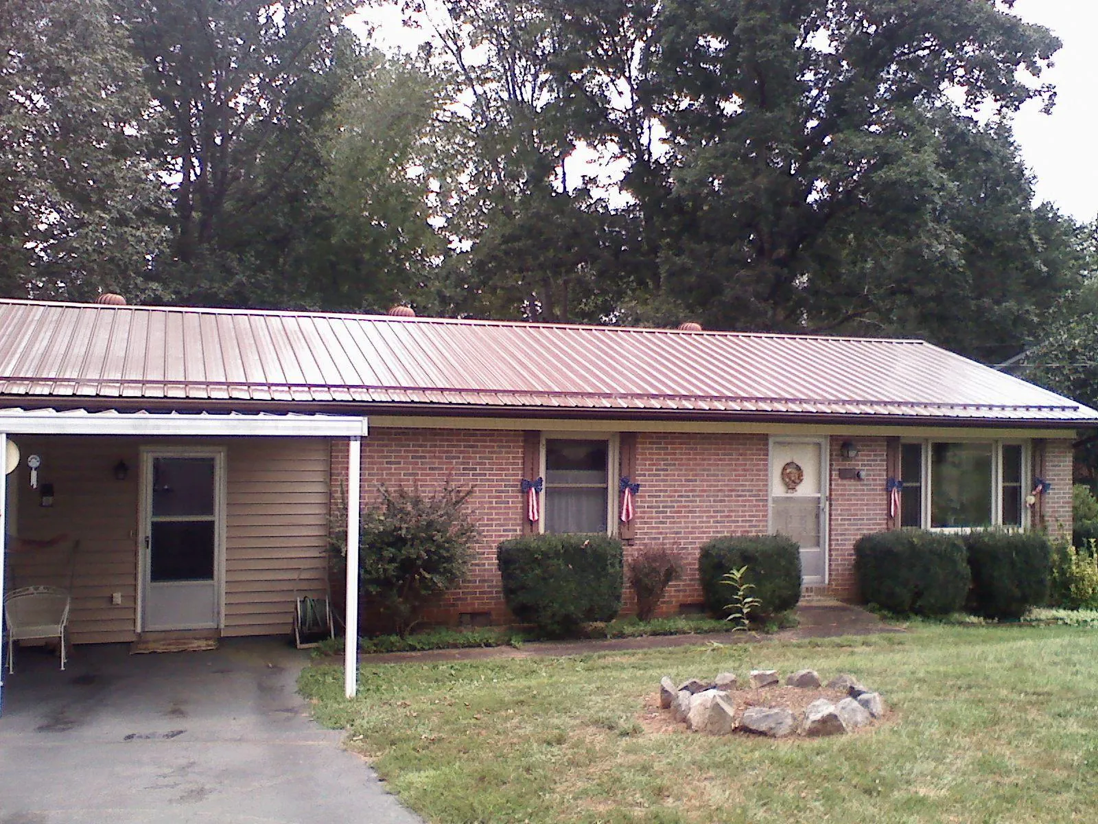 Bronze metal roof and carport on a brick ranch home — Roof Repair work by our crew in Blacksburg